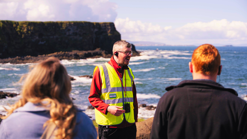 Member of the Giant's Causeway Storytelling team delivering a guided tour to a group of visitors